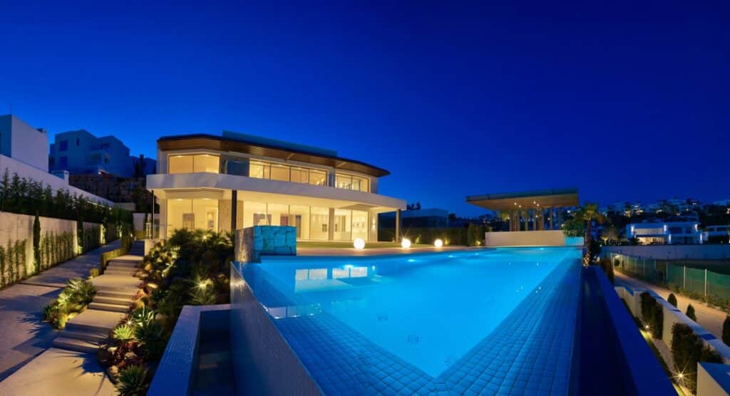 Nachtelijk zicht op verlicht zwembad en Villa Te koop in Benahavis in Spanje, gelegen aan de Costa del Sol-West