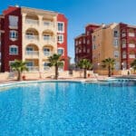 Gemeenschappelijk zwembad en vooraanzicht van nieuwbouw appartementen in Los Alcazares in Spanje, gelegen aan de  Costa Cálida