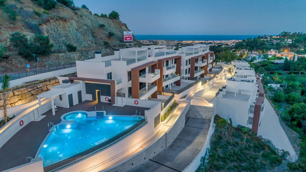 Luchtfoto, gemeenschappelijk zwembad en vooraanzicht van resale appartementen in Benahavis in Spanje, gelegen aan de  Costa del Sol-West