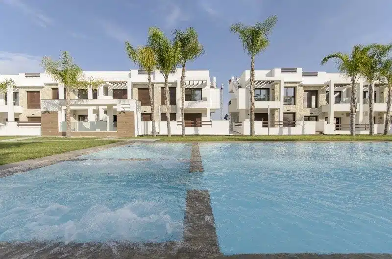 Gemeenschappelijk zwembad en vooraanzicht van nieuwbouw appartementen in Torrevieja in Spanje, gelegen aan de  Costa Blanca-Zuid